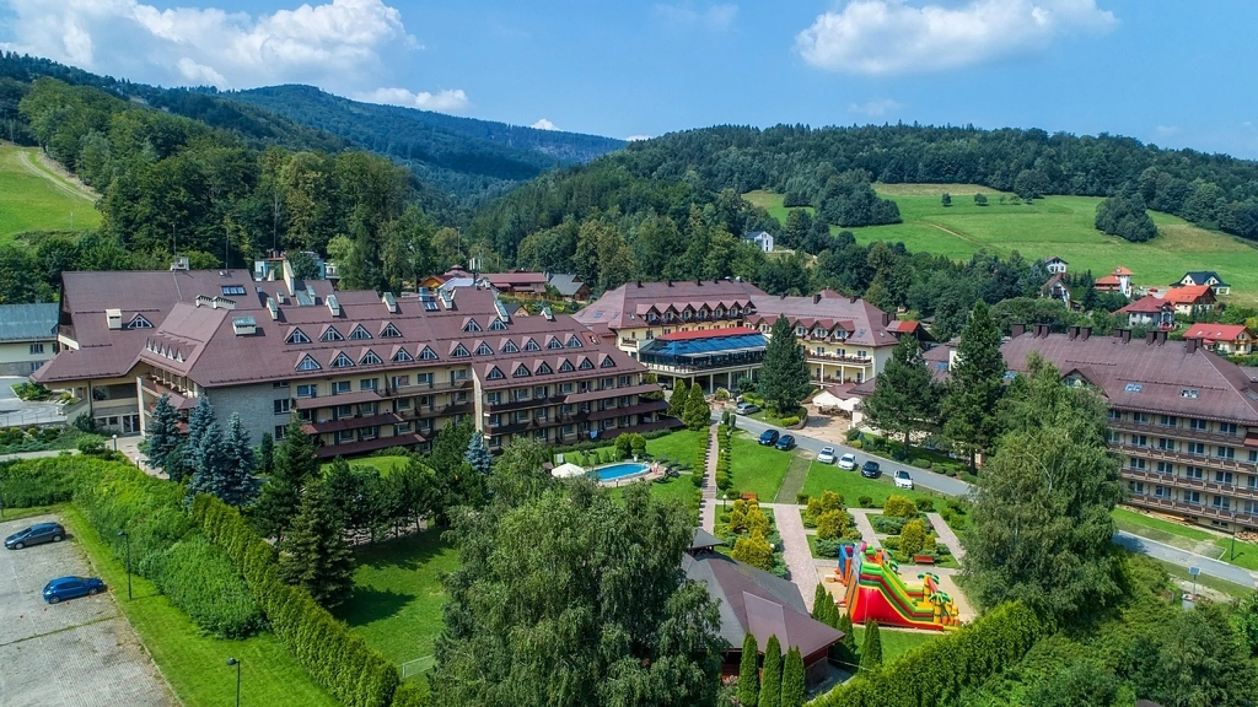 Kompleks hotelowo-szkoleniowy w górskiej okolicy, otoczony zielenią, gdzie odbywa się I Zjazd Szkoleniowo-Integracyjny Izby Branży Komunalnej.