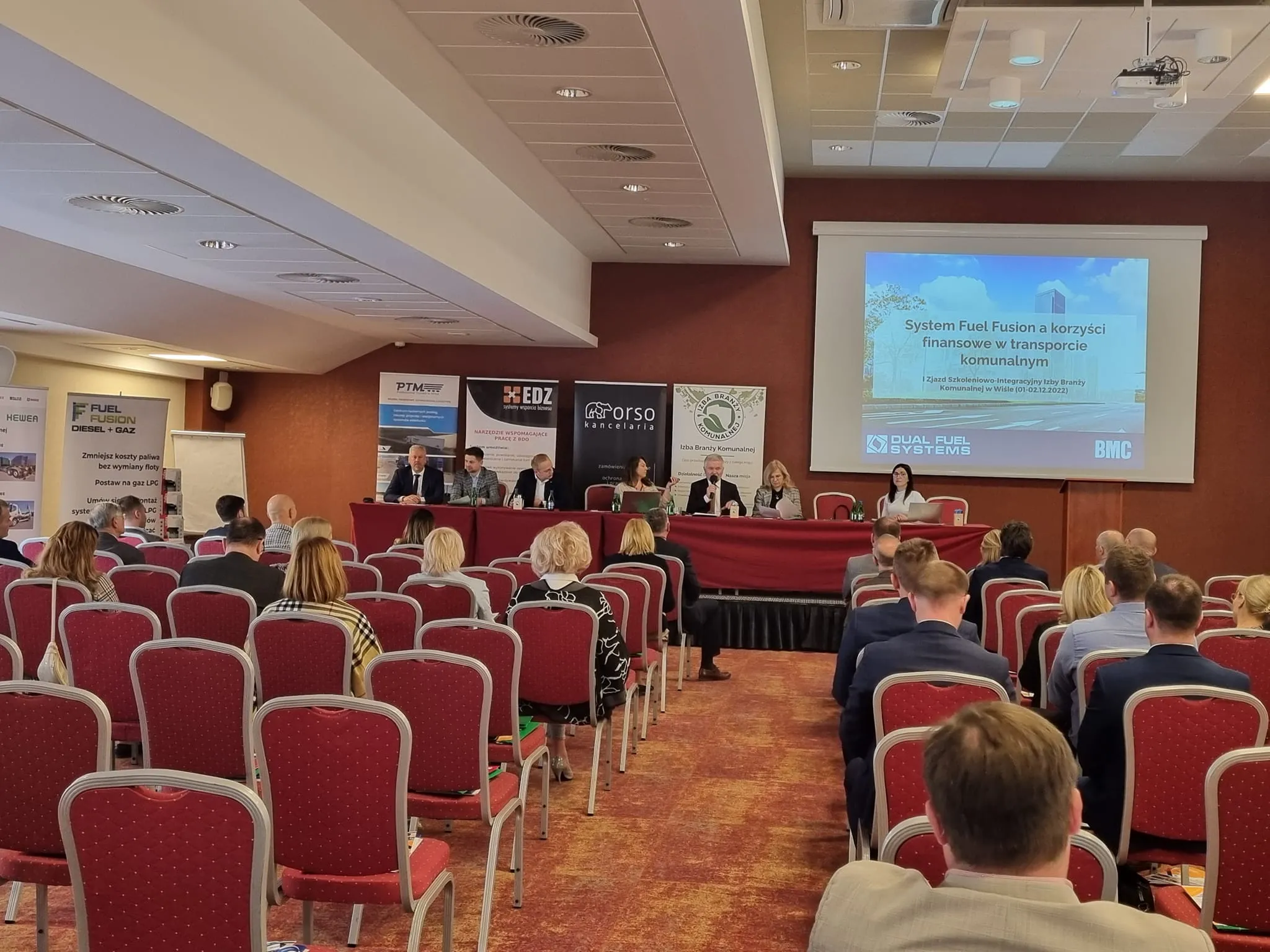 Uczestnicy I Zjazdu Szkoleniowo-Integracyjnego Izby Branży Komunalnej siedzą w sali konferencyjnej i słuchają prelekcji o systemie Fuel Fusion i korzyściach finansowych w transporcie komunalnym.