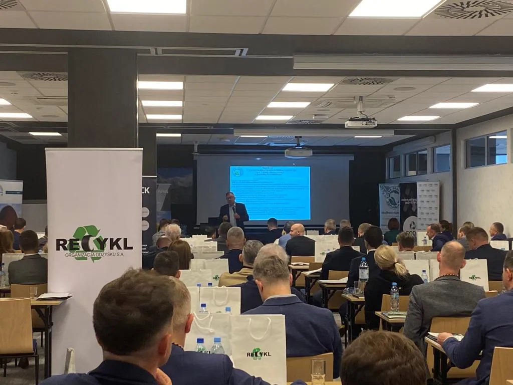 Uczestnicy II Zjazdu Szkoleniowo‑Integracyjnego siedzą w sali konferencyjnej i słuchają prelegenta prezentującego slajdy na dużym ekranie.